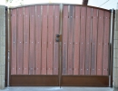 driveway gate with a simple arch and plate steel kickplate 